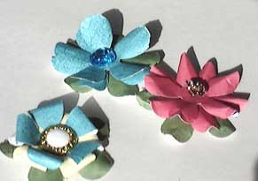 three variations of paper flowers made from a punch